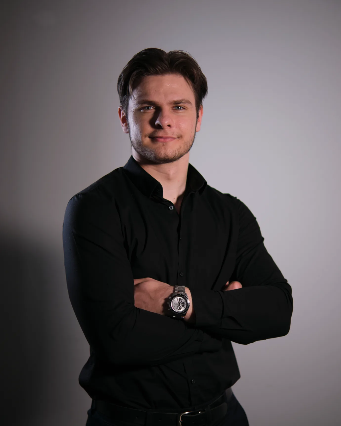 Nick Fleckenstein, freiberuflicher Webentwickler aus Ludwigshafen am Rhein, mit verschränkten Armen vor einem grauen Studiohintergrund